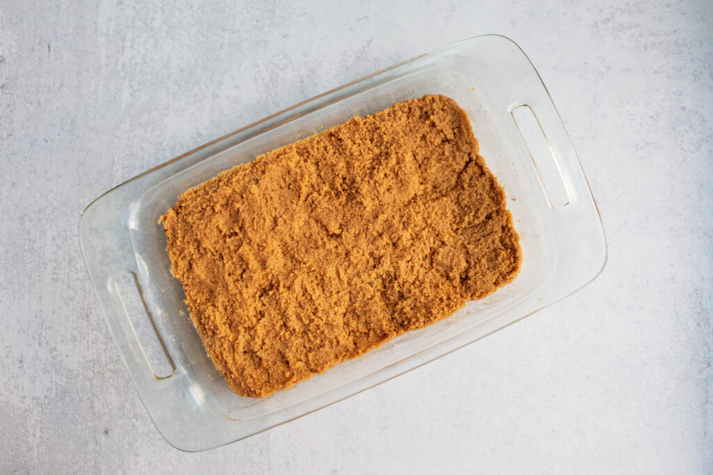overhead view of unbaked brown pumpkin bars batter inside glass casserole dish