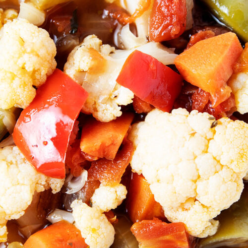 closeup view of veggie soup with carrots, green beans, red peppers and cauliflower