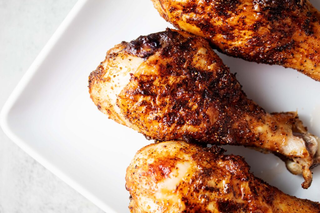 overhead view of 3 air fryer chicken legs on a white serving dish