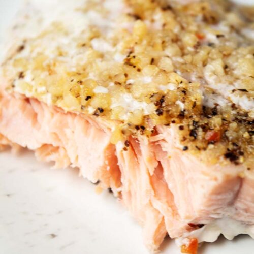 sideview of garli and lemon salmon on a white serving dish