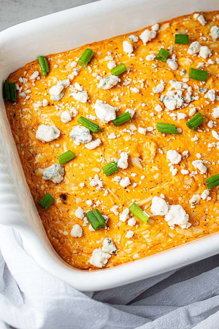 overhead view of buffalo chicken dip garnished with green onions and blue cheese crumbles
