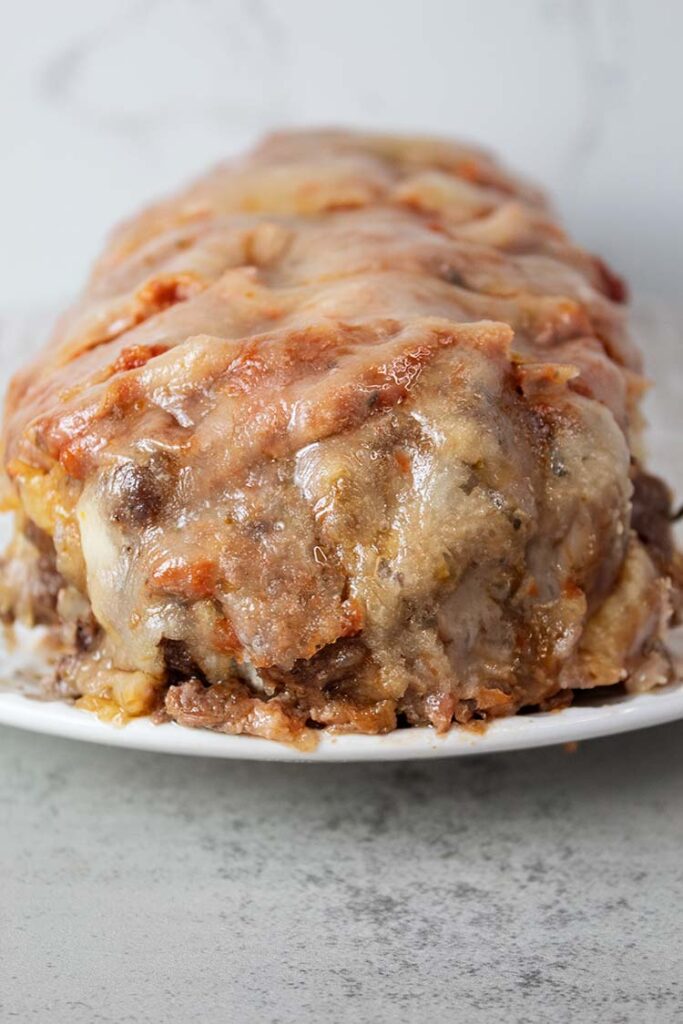 sideview of italian meatloaf covered in melted mozzarella cheese