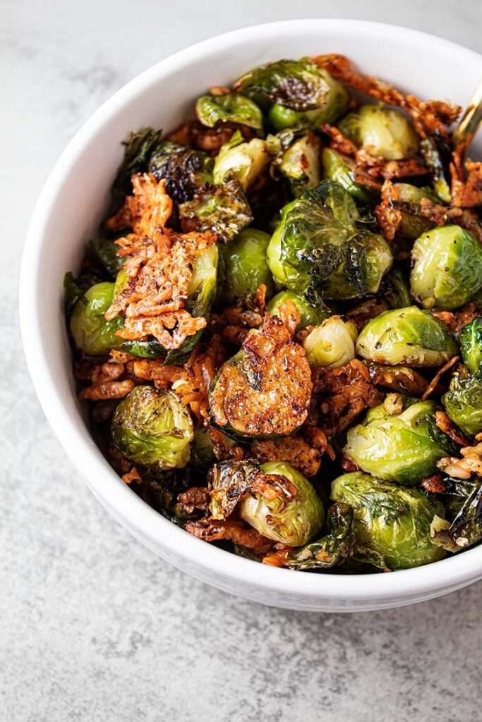 overhead view of oven roasted brussels sprouts in a white serving bowl