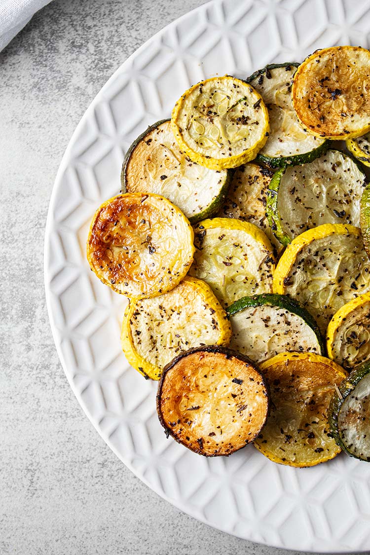 overhead view of roasted zucchini and squash on a white serving dish