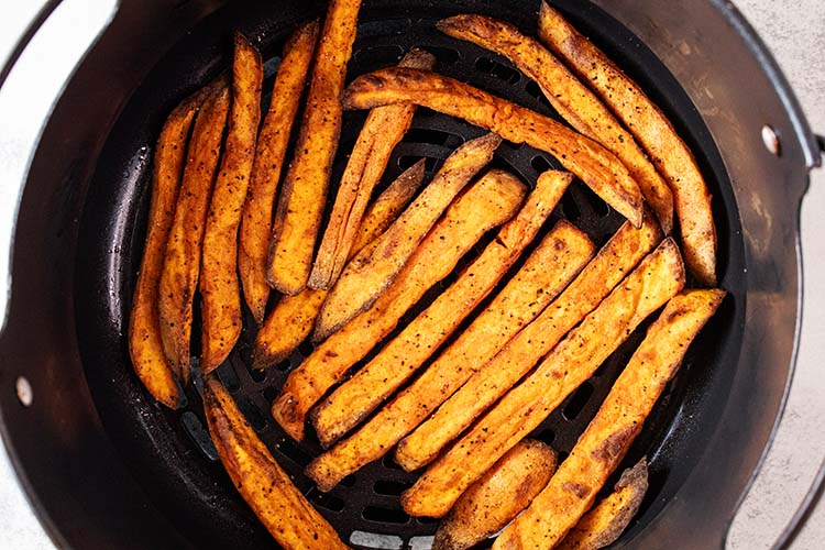 overhead view of sweet potato fries in the air fryer basket