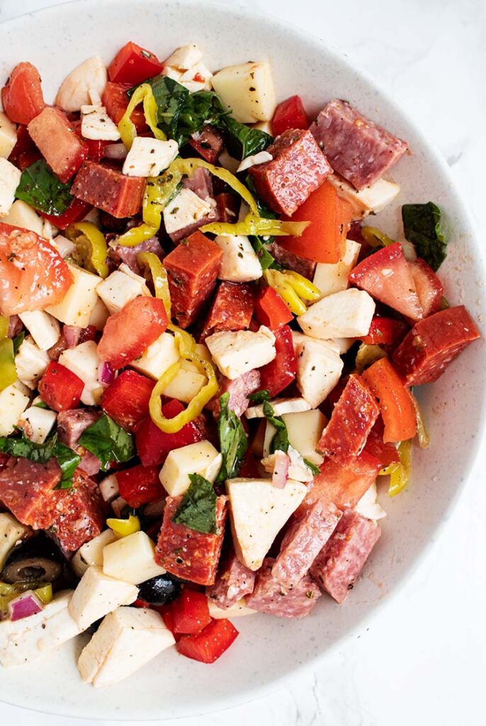 overhead view of antipasto salad in a white serving bowl