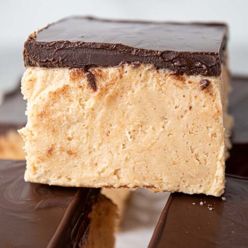 sideview of numerous peanut butter heaven dessert bars topped with chocolate ready to serve