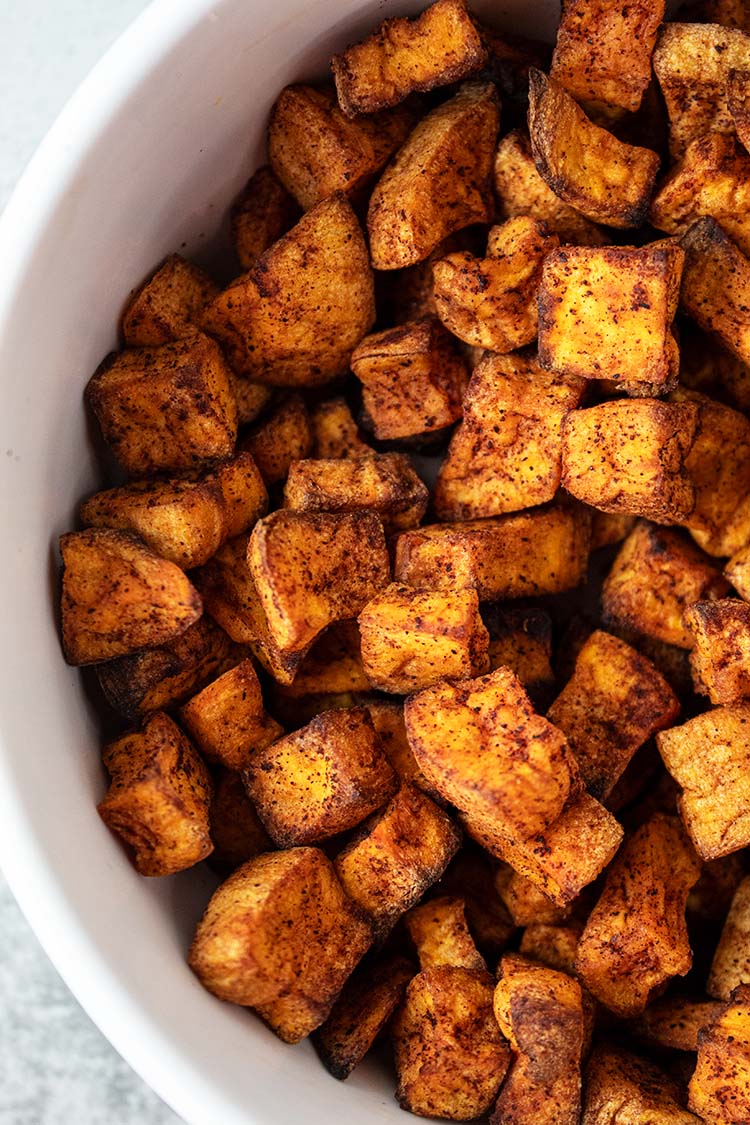 overhead view of white serving bowl with air fryer sweet potato bites
