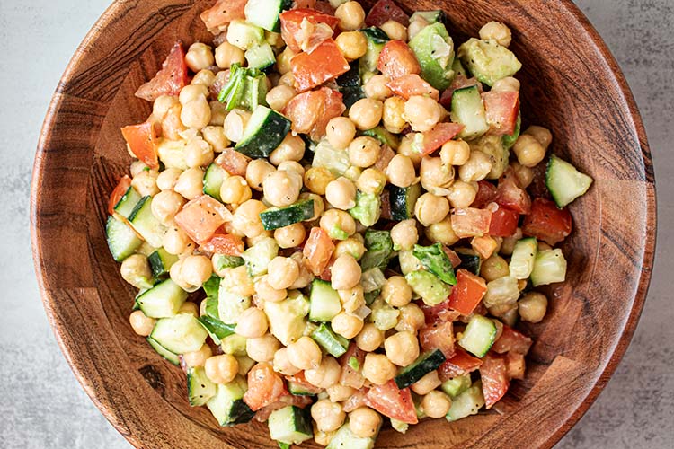 overhead view of chickpea salad in a wooden bowl mixed and ready to serve