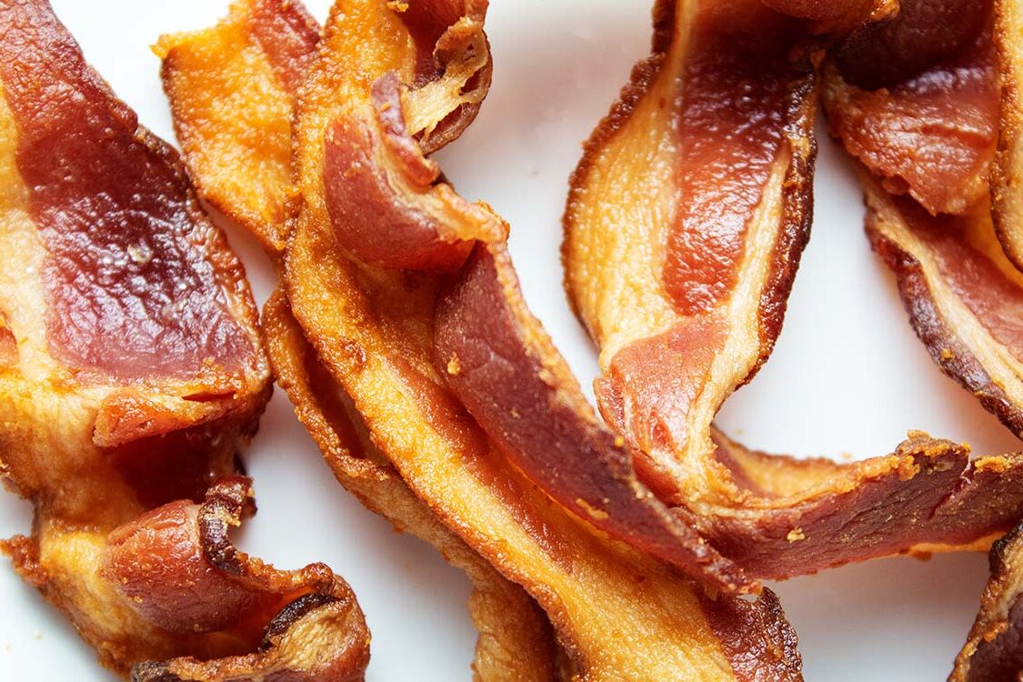 overhead view of air fryer bacon ready to serve on a white surface