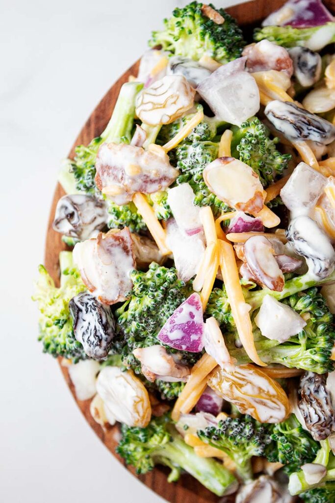 overhead closeup view of broccoli salad in a wooden serving bowl
