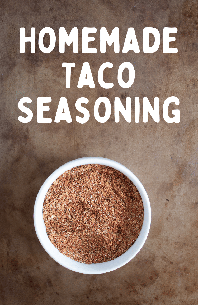 overhead view of bowl of homemade taco seasoning mixed in a small white bowl on a brown colored background