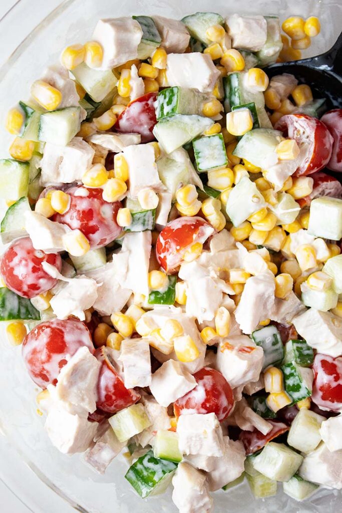 overhead view of chicken corn salad in a glass serving bowl