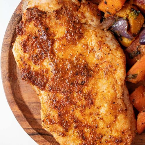 overhead view of seasoned and ready to serve air fryer pork chops on a wooden serving dish