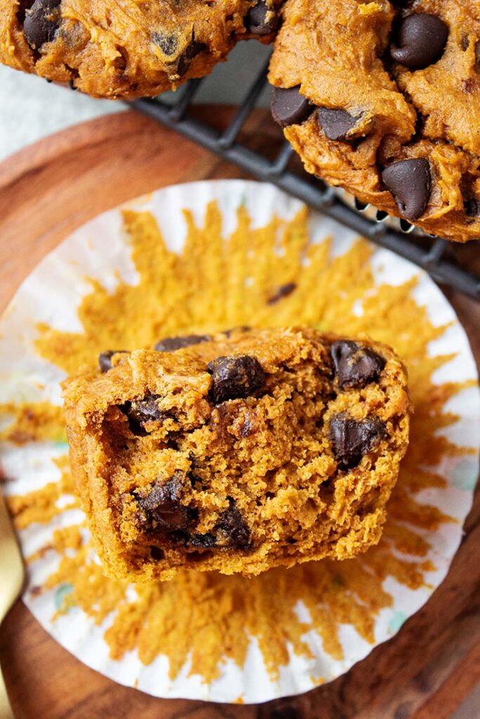 overhead view of 3 ingredient pumpkin chocolate chip muffins with cupcake liner removed and partially eaten
