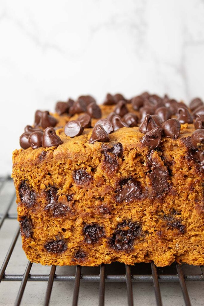 sideview of pumpkin bread with chocolate chips 3-ingredients baked and cooling on a wire rack