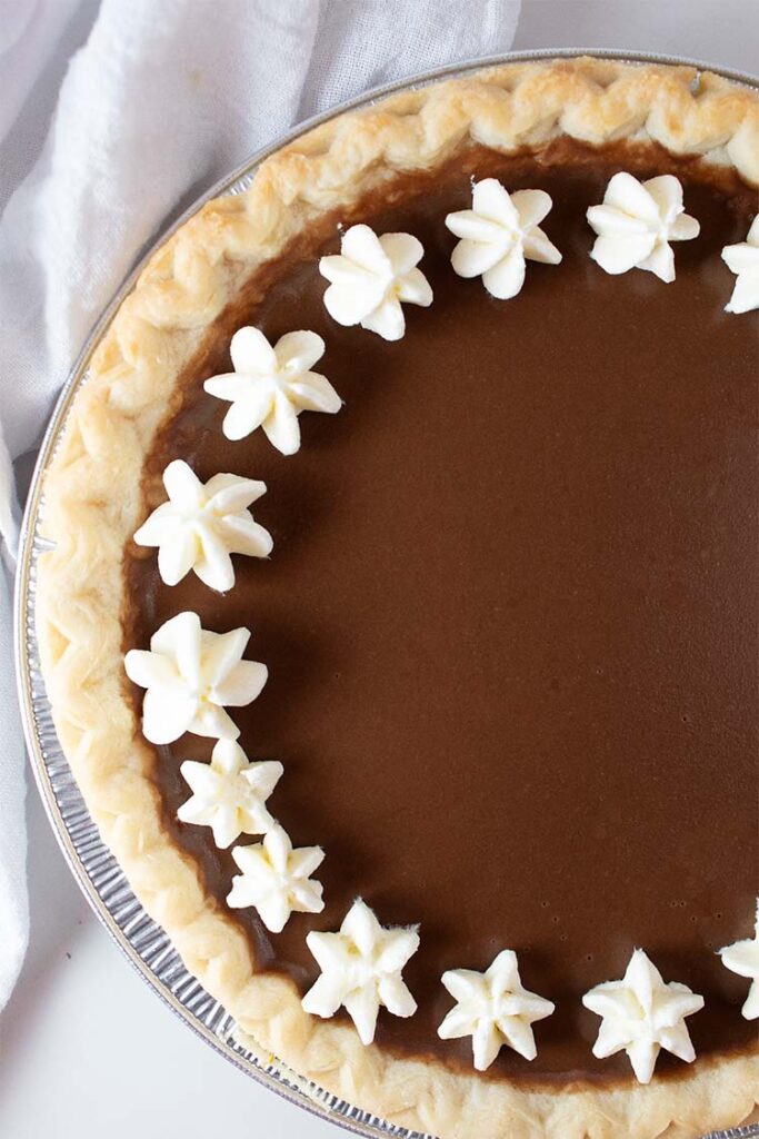 overhead view of chocolate pudding pie with whipped cream around the outer rim of the pie ready to serve