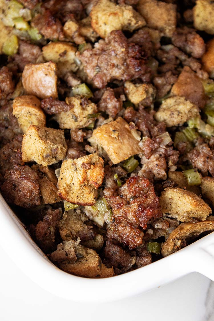 overhead view of sausage stuffing out of the oven in a white casserole dish and ready to serve