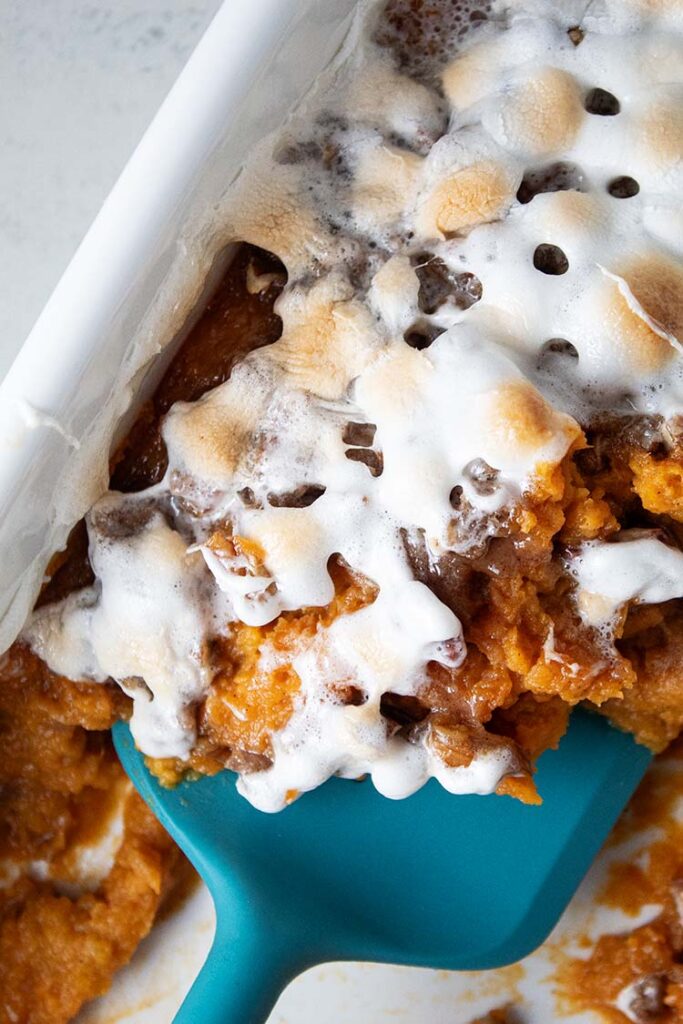 overhead view of sweet potato casserole ready to serve with blue spatula