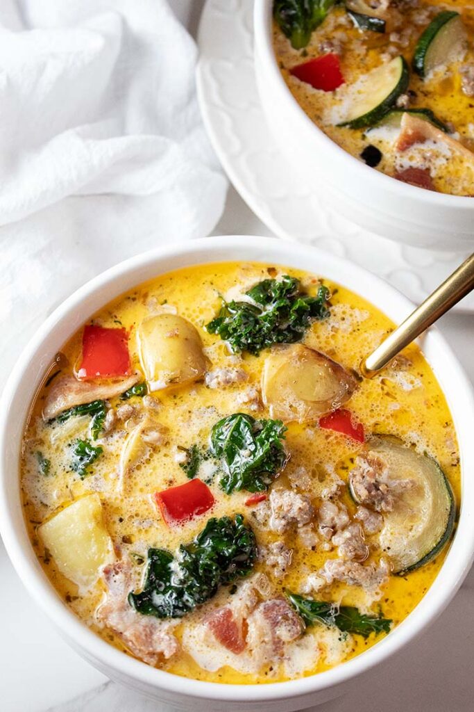 overhead view of Italian zuppa toscana soup in a white serving bowl with a spoon