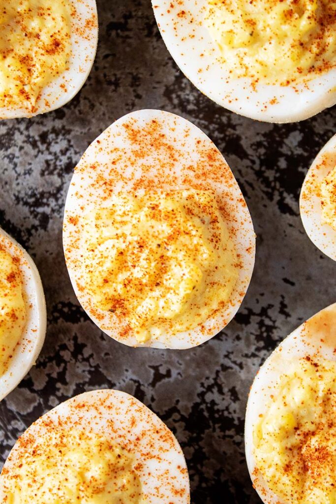 overhead view of deviled eggs topped with paprika ready to serve