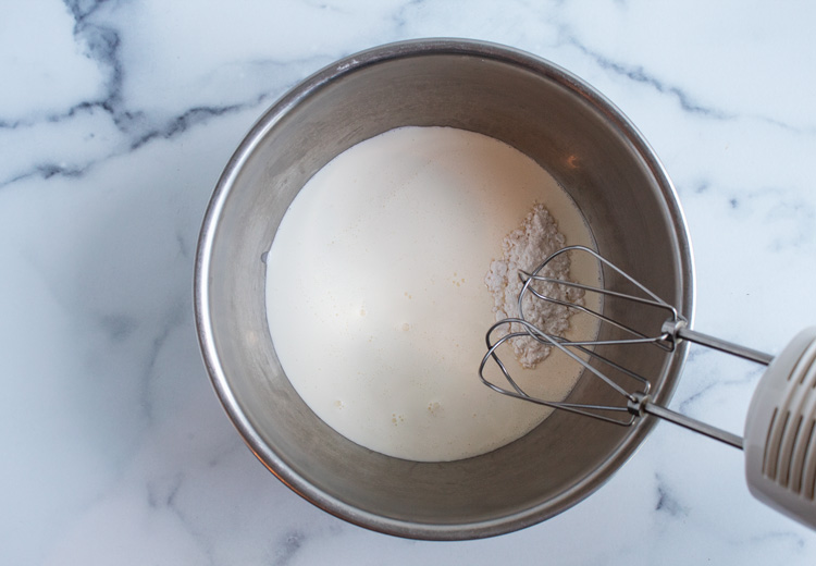 overhead view of heavy cream and confectioners sugar about the be combined with mixer