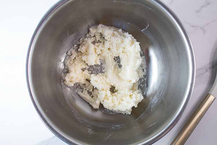 overhead view of butter and sugar mixed in a silver mixing bowl