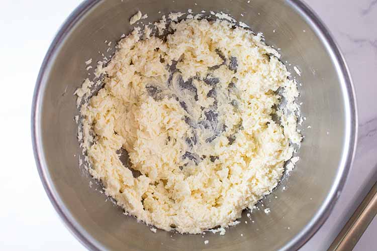 overhead view of butter mixture combined with eggs in a mixing bowl