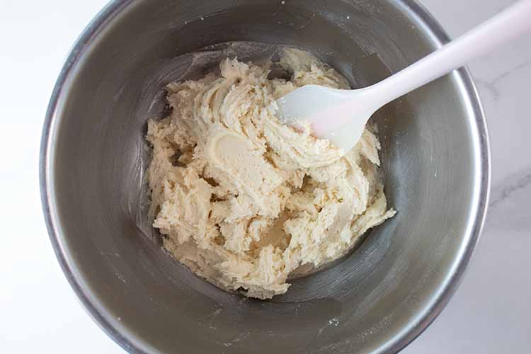 overhead view of butter and egg mixture combined with the dry ingredients in a mixing bowl