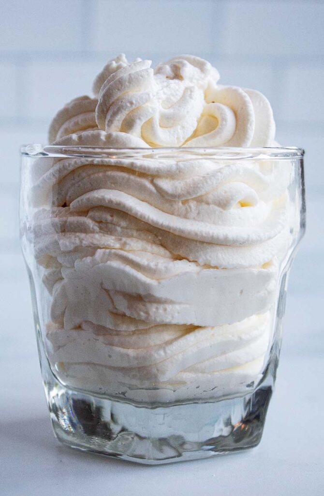 sideview of homemade whipped cream in a glass ready to be served