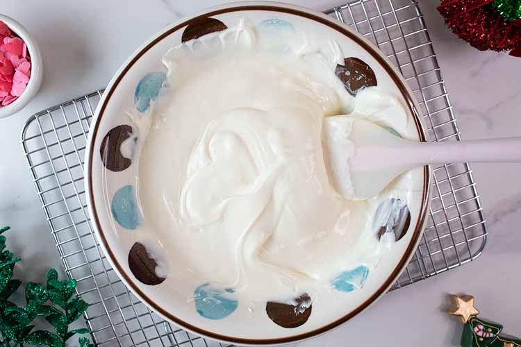 melted chocolate and sweetened condensed milk thoroughly mixed in a bowl with a silicone spatula