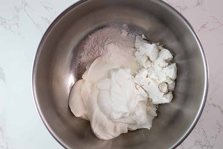 overhead view of yogurt, and pudding mix added to mixing bowl
