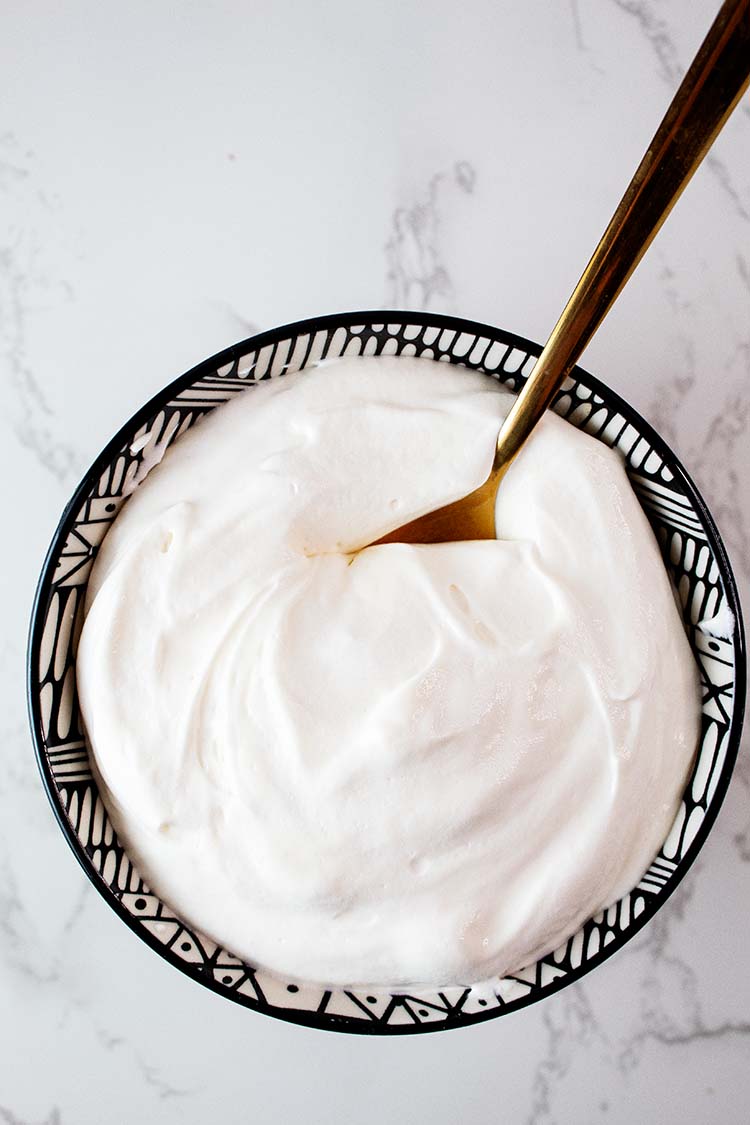 overhead view of cheesecake fluff with high protein in a serving bowl with a gold spoon