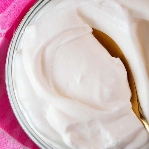 overhead view of high protein cheesecake fluff in a serving bowl and gold serving spoon in it