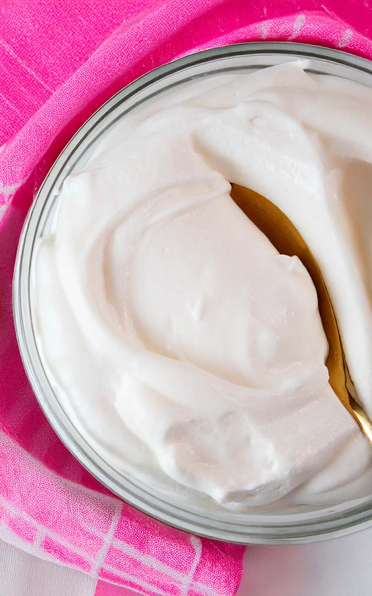 overhead view of high protein cheesecake fluff in a serving bowl and gold serving spoon in it
