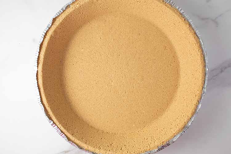 overhead view of graham cracker pie crust ready to have no bake cheesecake added