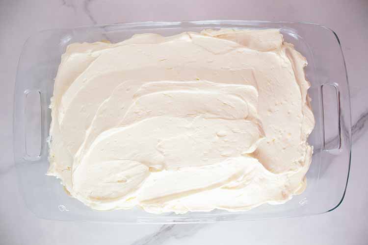 overhead view of banana pudding with all six layers and ready to be topped with crushed wafers and chilled in the refrigerator