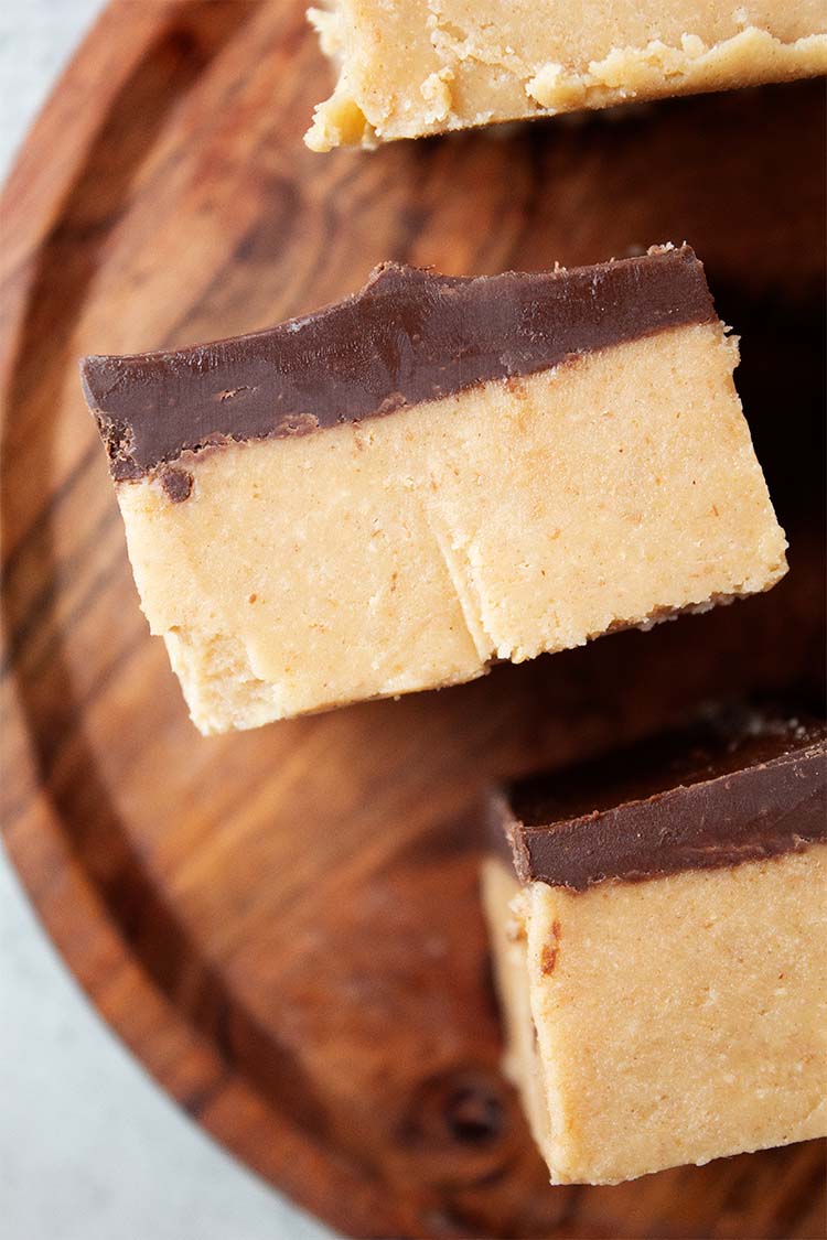 overhead view of no-bake peanut butter bars laying on their side on a wooden serving dish