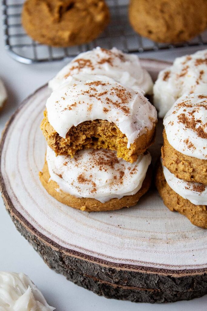 sideview of pumpkin cookies with cream cheese frosting on a serving platter