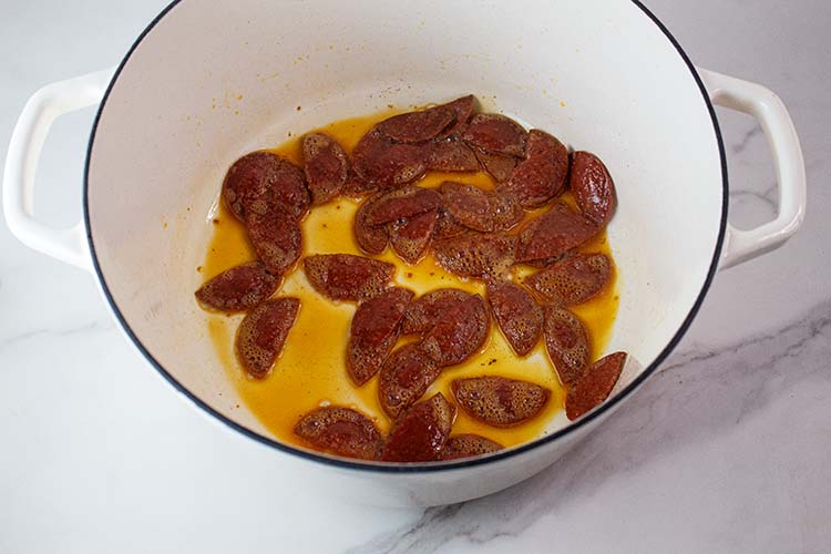 overhead view of pepperoni added to the cooking pot