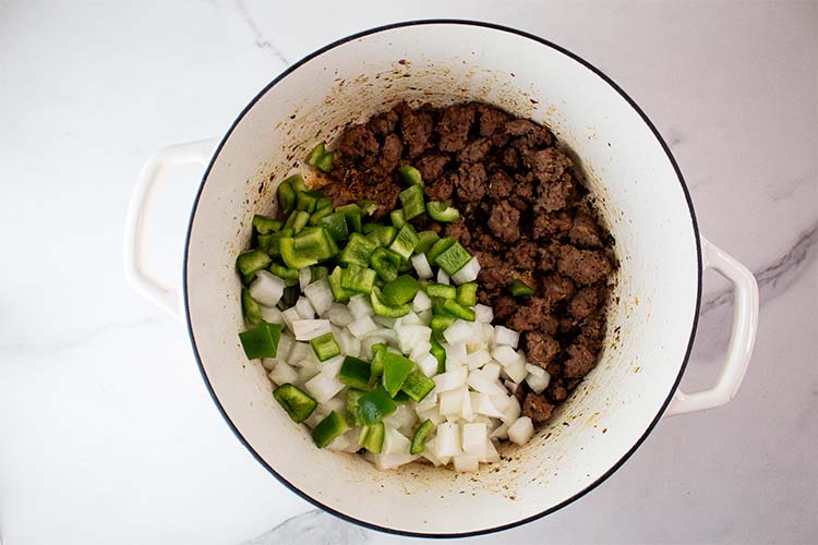 overhead view of pepperoni removed and onions, peppers and sausage added