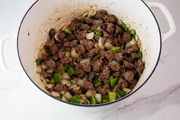 overhead view of serving pot with combined onions, peppers and sausage