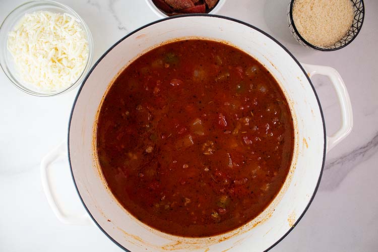 overhead view of cooking pot with soup base and cheeses ready to be added