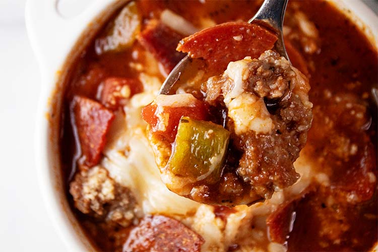 overhead view of pizza soup in a bowl with a small spoonful being removed