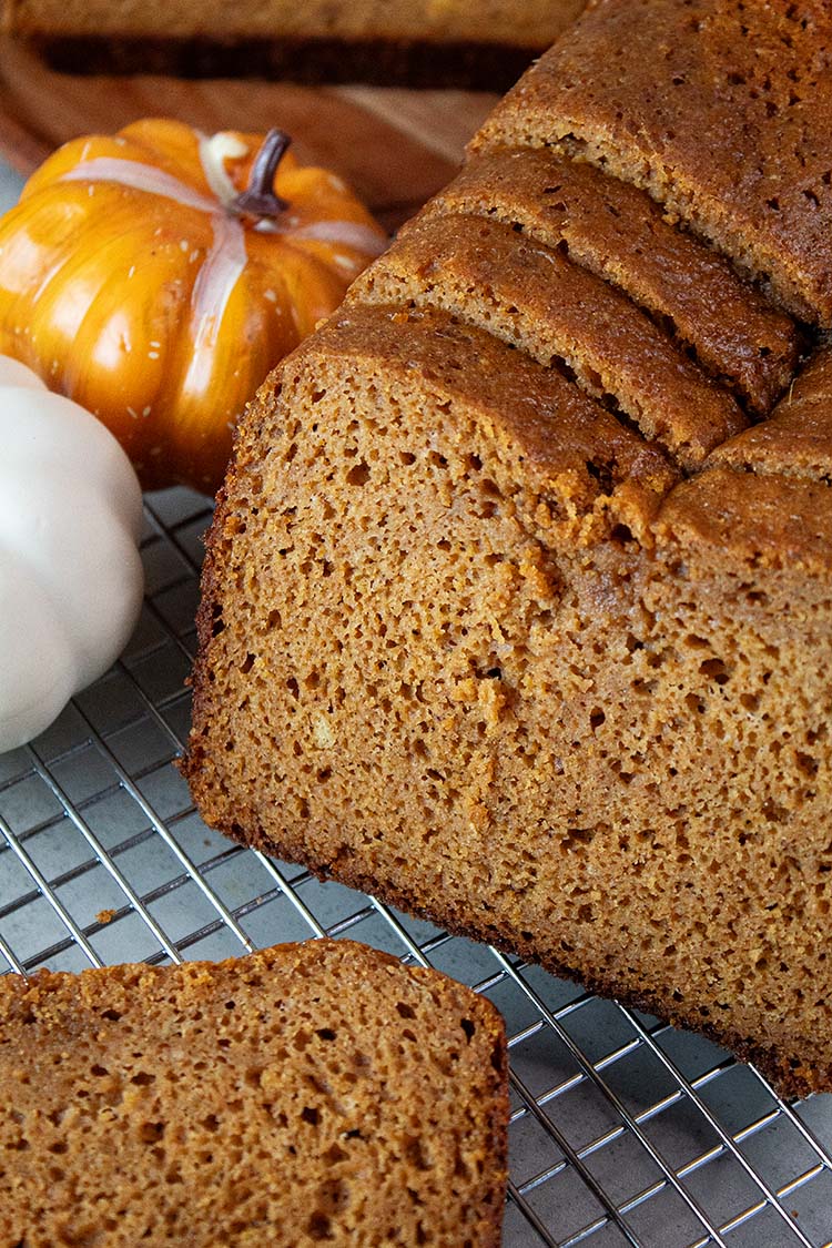 sideview of slices of high protein pumpkin bread on a wire cooling rack